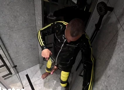 Rubber Man Pisses with Uncut Cock
